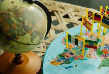 Geographic Education - Globe and a Flat World Map With Country Flag Markers